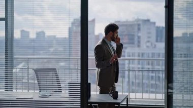 Endişeli patron şehir merkezindeki cep telefonuyla konuşuyor şık bir takım elbise giyiyor. Stresli iş adamı akıllı telefon konuşması yapıyor. Sinir yöneticisi panoramik pencerelerde el kol hareketi yapıyor. 