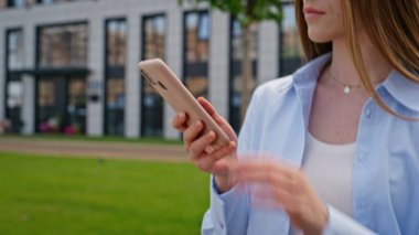 Uygulamalı cep telefonuyla gezen kız sokak kapanışı. Uzun saçlı iş kadını ofis işlerine giderken cep telefonundan iş e-postalarını okuyor. Kendine güveni tam bir kadın. Şehir merkezinde geziniyor. Akıllı telefon gibi görünüyor.