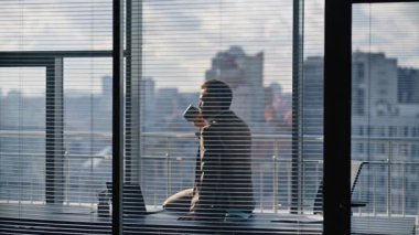 Düşünceli yönetici görünümlü şehir hayatı düşünüyor. Ofis müdürü elinde kahve fincanı ile dinlenme işini sıcak içecekle durduruyor. İş adamı masasında içkisini yudumlarken profesyonel yolculuğu düşünüyor.