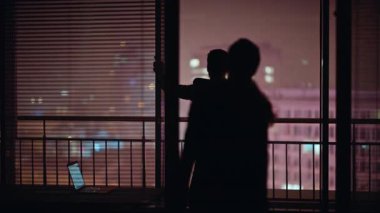 Adam silueti gece görüş camında duruyor. Karanlığa giren rahat bir kadın kocasıyla konuşuyor. Birbirlerine aşık iki kişi panoramik pencereyi kucaklıyor. Aşk ilişkileri