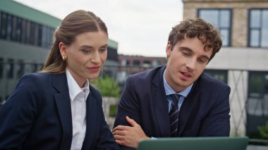 Sanal toplantıda konuşan iş adamları dışarıdaki terasta dizüstü bilgisayara bakıyorlar. Sokak Kafe 'den kendine güvenen iş arkadaşlarının videosu. Ortaklar online konferansta iş tartışırken takım çalışmasının keyfini çıkarıyorlar