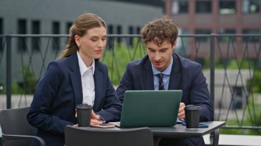 Şirket yöneticileri dışarıda dizüstü bilgisayarda odaklanmış ifadeyle çalışıyorlar. Profesyonel iş arkadaşları masa ofis terasında proje üzerinde çalışıyor. Meslektaşlar kafeteryada fikir alışverişi yapıyorlar..