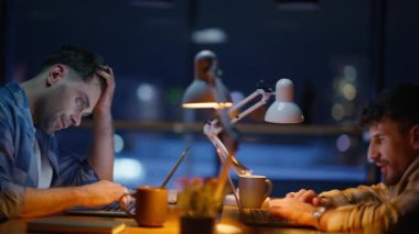 Yorgun adam gece vardiyası kapanışı. Yorgun adam, panoramik gece ofisinde erkek meslektaşının önünde bilgisayarını kapatıyor. İş adamları iş günlerini aşırı çalışmayla noktalıyorlar. Görev rutini