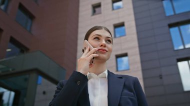 Kadın patron modern ofis binasının yakınında cep telefonundan konuşuyor. Şık bir iş kadını şehir sokağında akıllı telefondan arıyor. İş bölgesinde cep telefonuyla konuşan genç bir bayan yönetici..