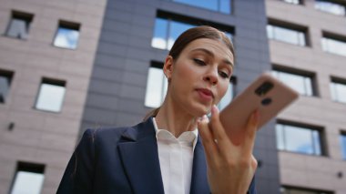 Akıllı telefon hoparlörüyle bağıran kızgın bir yönetici modern ticaret bölgesini kapatıyor. Sinirli iş kadını cep telefonu konuşmasını bitirdi. Endişeli kadın CEO ofisin dışında cep telefonuyla tartışıyor..