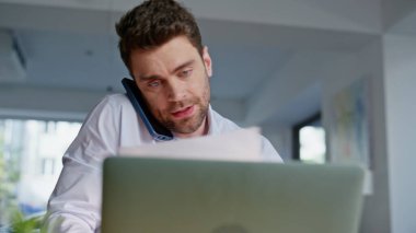 Ofiste cep telefonundan konuşan birden fazla iş adamı yakın çekimde belgeleri okuyor. Yönetici, iş yerinde laptopta çalışan ortakları arıyor. Profesyonel danışman akıllı telefon görünümlü kağıtları konuşuyor.