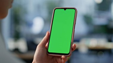 Eller Chromakey cep telefonunu kaydırıyor ve yakın çekimde online alışverişleri seçiyor. Bilinmeyen iş kadını yeşil ekran cep telefonundan mesaj arıyor. Ofiste akıllı telefon kullanan genç bir bayan..