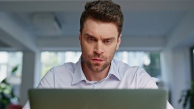 Modern bir iş yerinde dizüstü bilgisayarda çalışan gergin, serbest çalışan biri. Ofisteki görevdeki bilgisayar ekranına bakarak kaşlarını çatmış bir yönetici. İş yerinde ciddi girişimci sorunlu çözümler üzerinde kafa yoruyor