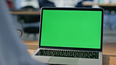 Ofis alanındaki Chromakey Laptop 'ta çalışan bir yönetici. Tanımlanamayan iş kadını dokunmatik ped kullanarak yeşil ekran bilgisayarına bakıyor. Kadın serbest çalışan, dijital model aygıt hakkında bilgi arıyor