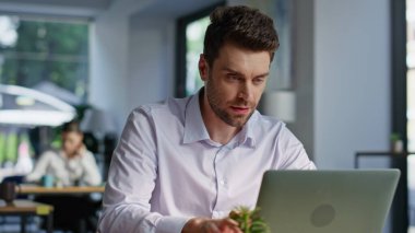 Heyecanlı iş adamı laptopta çalışırken sevinçten havalara uçuyor. Gülümseyen girişimci çalışma alanında harika haberler okuduğu için mutlu. Duygusal erkek menajer bilgisayar aramanın keyfini çıkarıyor.