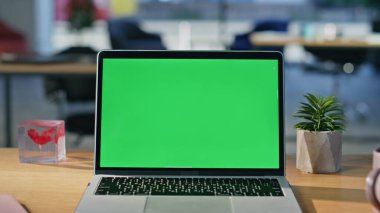 Ofis masasında duran model dizüstü bilgisayar. Yakın plan. Modern yeşil ekran bilgisayar, kurumsal açık alanda çevrimiçi iş yapmak için açılıyor. Krom anahtar dijital aygıt ahşap masa boş şirket işyeri üzerine yerleştirildi