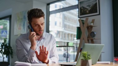 Şirketin CEO 'su cep telefonuyla şikâyet ediyor modern şirket ofislerini kapatıyor. Sinirli iş adamı akıllı telefonu arıyor ve anlaşmazlık yaşıyor. Stresli yönetici telefon konuşmasında bağlantı sorunu tartışıyor.