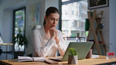 Modern çalışma alanında odaklanmış profesyonel bir bilgisayar. Ofiste dizüstü bilgisayarı geliştiren ciddi bir iş kadını. Zarif bayan girişimci planlama stratejisi oluşturuyor..