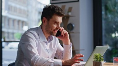 Olumlu şirket çalışanı modern iş yerindeki cep telefonunu arıyor. Gülümseyen iş adamı cep telefonu konuşmalarında ofis bilgisayarındaki not defterini tartışıyor. Meşgul yönetici akıllı telefondan konuşuyor.