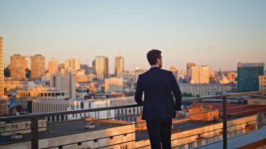 Hırslı girişimci, gün batımı kentsel manzarasını izliyor. Kendine güvenen işadamı, ofisin çatısında dinleniyor ve akşam manzarasının tadını çıkarıyor. Kararlı adam şirket lideri ufuk çizgisini düşünüyor..