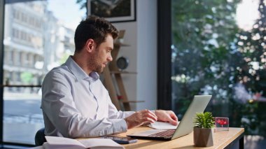 Bilgisayarda çalışan mutlu muhasebeci iş belgelerini yakından inceliyor. Gülümseyen işadamı ofis bilgisayarından veri girişi raporlarını okuyor. Başarılı yönetici, finansal belgeleri gülümseyerek gözden geçiriyor..
