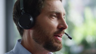 Teknik asistan kulaklıkla konuşuyor çağrı merkezinde çalışıyor. Portre sakallı adam müşteriye danışıyor. İş yerindeki teknik talebi çözüyor. Profesyonel destek acentesi kulaklıklı müşteriye tavsiyede bulunuyor