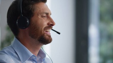 Modern ofiste profesyonel teknik destek sağlayan çağrı merkezi operatörü daktilo bilgisayarı. Sakallı adam kulaklıklı danışman müşteriyle konuşuyor. Müşteri talebini analiz eden servis uzmanı.