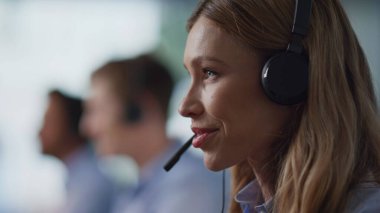 Teknik destek ekibi, ofisteki bilgisayarlarda çalışan müşterilere danışmanlık yapıyor. Profesyonel yardım hattı personeli kulaklıkla konuşuyor. Grup servis operatörleri müşterilere uzaktan danışmanlık yapıyor.