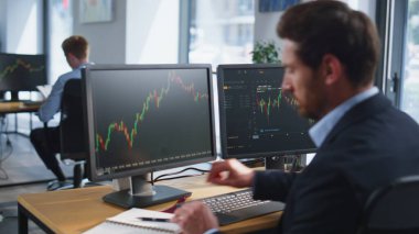 Finans şirketinin ofis alanındaki grafikleri analiz eden eski bir işlemci. Borsa haritalarıyla monitörlere bakan profesyonel bir finansör. Yatırım planlayan işadamı.