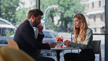 Kafe masasında oturan ciddi meslektaşlarım iş problemlerini tartışıyor. Gergin iş adamları modern kafeteryadaki kahve molasında finansal krizi düşünüyorlar. Sorunları çözen düşünceli çiftler..