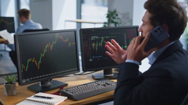Finans tüccarı, birden fazla monitörü olan akıllı telefon oturma yeriyle konuşuyor. Sakallı işadamı ofisteki borsa grafiklerini inceliyor. Komisyoncu telefonda yatırım stratejisini tartıştı