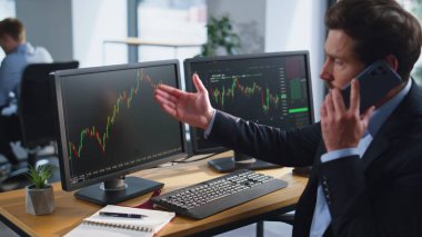 Stresli tüccar cep telefonunu arıyor. Ofisin iş yerinde yaşanan mali kayıptan yakınıyor. Sinirli komisyoncu akıllı telefon konuşmasını bitirdi. Bunalımlı yatırımcı telefonda konuşurken, borsa verileri hakkında endişeli