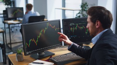 Finansör, birden fazla monitörde hisse senedi borsası grafiklerine bakarak finansal kaybını engellemiş. Eski tüccar Kripto değiş tokuş bürosunda açık alanda para kaybediyor. Stresli yatırımcı grafikleri analiz ediyor