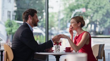 Sıcak bir kafede el ele tutuşan sevimli bir çift. Gülümseyen sakallı adam restoranda kırmızı elbise giyen sevgili bir kadınla konuşuyor. Sevgili, masadaki güzel kız arkadaşına aşkını itiraf ediyor.