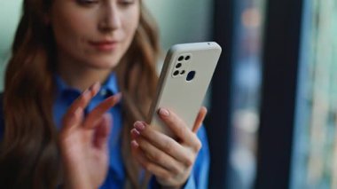 Açık bir apartmanda akıllı telefondan esmer alışverişi. Gülümseyen kadın rahat evdeki cep telefonu uygulamasını kullanarak internet alımlarını tatmin ediyor. Oturma odasında cep telefonu mesajı okuyan mutlu bayan.