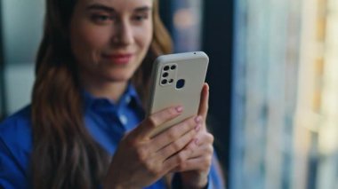 Oturma odasında akıllı telefon mesajlarına bakan neşeli bir kadın. Gülümseyen iş kadını hafif ofisteki bankacılık mobil uygulamasına göz atıyor. Mutlu bayan serbest çalışan evde cep telefonu mesajları okuyor. 