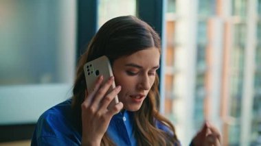 Modern ofiste cep telefonu tartışan duygusal bir iş kadını. Sinirli yönetici akıllı telefondan konuşuyor. Şirket patroniçesi cep telefonunu arıyor. Özel odada endişeli bir konuşma yapıyor.