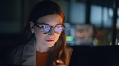Gece geç saatlere kadar çalışan kadın borsacı bilgisayar kapanışında işlem yapıyor. Gözlüklü bir iş kadını dizüstü bilgisayardaki finansal verileri analiz ediyor. Çizelgeleri gözden geçiriyor, gelecekteki strateji planlarına odaklanıyor. 