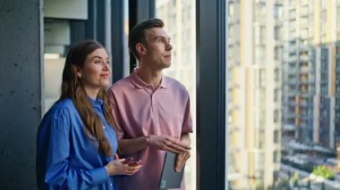 İş ortakları panoramik kabinede tablet planlama şirketinin büyümesini tartışıyor. Kendine güvenen meslektaşlar, stratejiyi analiz eden fikirleri modern ofis içlerindeki sekmeyle paylaşıyorlar. 