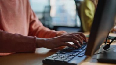 Eller bilgisayarın klavyesine yakın çekim yapıyor. Destek danışmanı, kulaklıkla konuşuyor. Neşeli adam tele-işçi müşteriye rehberlik ediyor. Pozitif temsilci yararlı çözümler arama monitörü öneriyor