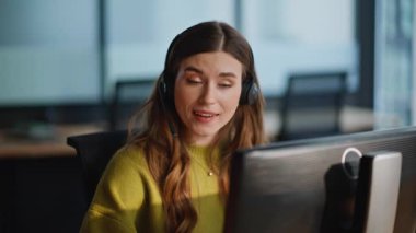 Gülümseyen operatör veri merkezinde bilgisayarla konuşuyor. İşteki neşeli kadın asistan. Müşteriye uzaktan bağlanan pozitif müşteri desteği tarayıcısı. Kulaklıklı mutlu ofis yöneticisi 