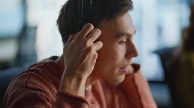 Ofiste müşteri danışmanlığı için kulaklık takan bir yardım hattı operatörü bilgisayara yakın çekim yapıyor. Arkadaş canlısı danışman müvekkil konuşuyor. Resepsiyonist yardım masasında profesyonel tavsiyeler veriyor.