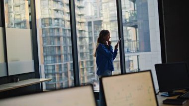 Modern ofis binasında akıllı telefon haberlerine tepki veren heyecanlı bir şirket yöneticisi. Lüks bir dolapta cep telefonu tutan aşırı mutlu bir iş kadını. Duygusal kadının başarı kazanması mutlu hissettiriyor.
