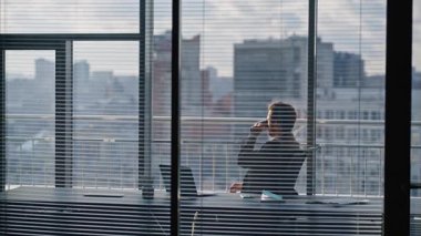 Zengin biri kahve molası veriyor lüks bir ofiste oturuyor ve pencereye bakıyor. Düşünceli sakallı genel müdür işyerinde içki içiyor. Sakin bir yönetici takım elbise giyip tek başına şehir dışına bakıyor.