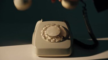 Akşam odasında eli dönen telefondan çekiliyor. Tanımlanamayan iş adamı sabit bir telefona cevap veriyor. Retro iletişim cihazı gölgede masanın üzerinde duruyor. Vintage aracı.
