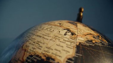 Retro Earth model rotating closeup. Beautiful vintage globe spinning in classroom. Different countries seas oceans marked on geographical sphere indoors. World map illustration on educational tool.