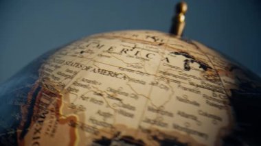 Kuzey Amerika coğrafyasını eğitim alanında gösteren yakın çekim küresi. Ayrıntılı harita nesnesi seyahat bilgisi için kapalı alanda dönüyor. Vintage Earth illüstrasyonu navigasyon ve öğrenme faaliyetlerini sembolize ediyor.