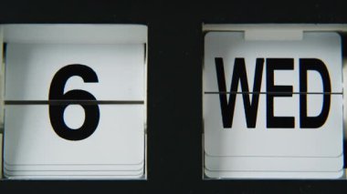 Saat değiştirme tarihi makro görünümü. Kapalı mekandaki plastik panellerde sayıları ve günleri gösteren ters saat takvimindeki Retro takvim. Odada çalışan eski bir elektronik cihaz. Eski tarz aygıt dekor.