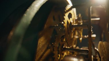 Geleneksel zaman cihazının içinde çalışan iç dişliler. Metal çarklar güneş ışığı altında vintage saat içinde dönüyor. Mekanik elementler hassas bir şekilde geriye dönük zaman dilimi hareket ediyor. Eski zaman tutma mekanizması.