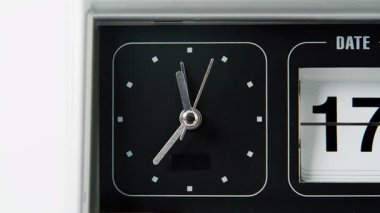 Metal eller saat üzerinde çalışıyor. Zaman akışını ölçüyor. İnce saniyelik ok, beyaz arkaplanda klasik ters saat hızında daire çiziyor. Makro görünüm retro zaman dilimi içeride duruyor ve saatleri gösteriyor.