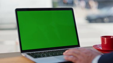 İşadamı parmaklarını kafeye yakın bir yerde çalışan bir dizüstü bilgisayara kaydırıyor. Bilinmeyen yönetici internet bilgilerini internette araklıyor. İşçi kapalı alandaki krom anahtarlı bilgisayara dokunuyor