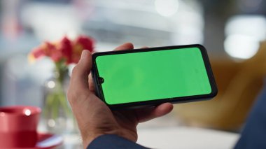 Eller Chromakey cep telefonuna sarılıp yakın çekimde online alışverişleri seçiyor. Bilinmeyen işadamı yeşil ekran cep telefonundan mesaj arıyor. İsimsiz bir adam kafede akıllı telefon kullanıyor.