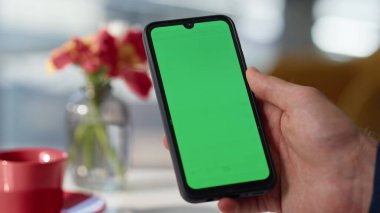 Lokantada yakın planda kullanıcı el kamerasında akıllı telefon var. Chroma Key 'de sosyal medyayı izleyen tanınmamış bir iş adamı. Adam yöneticisi yeşil ekran cep telefonunda çevrimiçi uygulamayı tarıyor