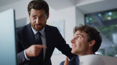 Hafif iş yerindeki sanal buluşmada birlikte konuşan gülümseyen iş arkadaşları. İki arkadaş canlısı iş adamı şirket kabinesinde online konferansta çalışmayı tartışıyor. Meslektaşlar video araması bilgisayarı