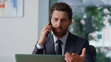 Kendine güvenen patron ofisteki cep telefonunu arıyor. Panoramik pencere işyerindeki akıllı telefondan konuşan odaklanmış bir adam. Neşeli sakallı iş adamı hafif özel kabinede çalışıyor.